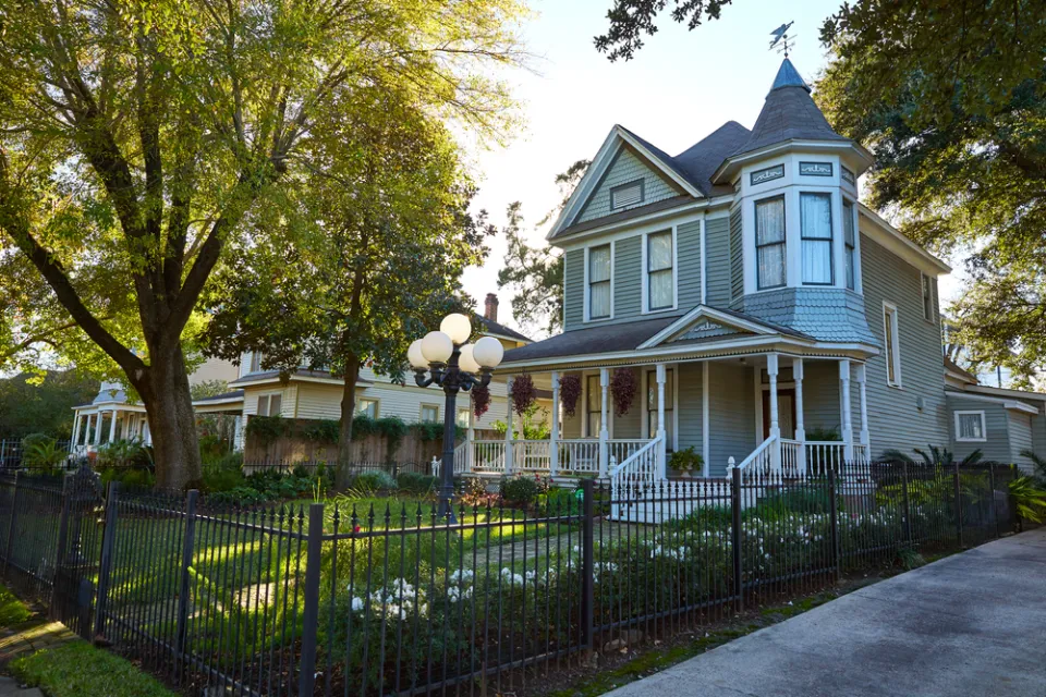 Light blue two-story Victorian home with corner turret in The Heights, Houston, Texas